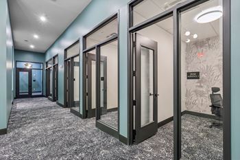 A hallway with glass doors and a carpeted floor.